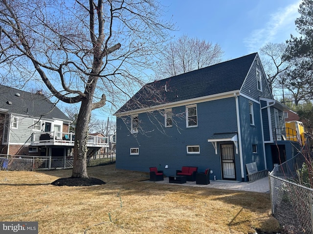 rear view of property featuring a yard, brick siding, and fence