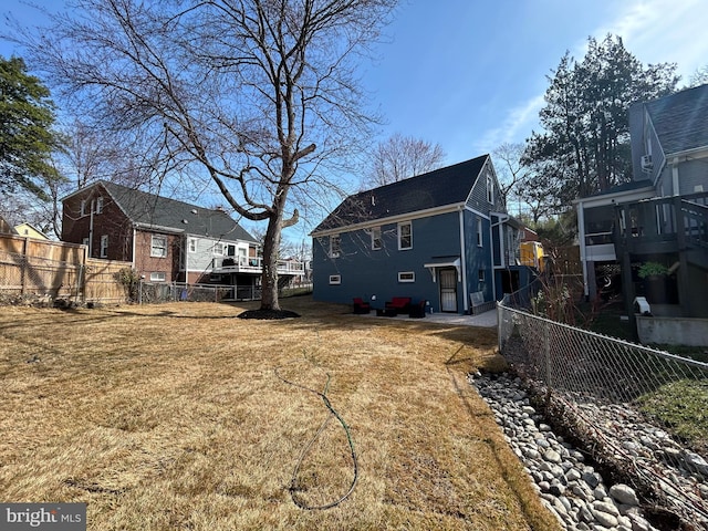 rear view of house featuring a residential view, a lawn, and fence