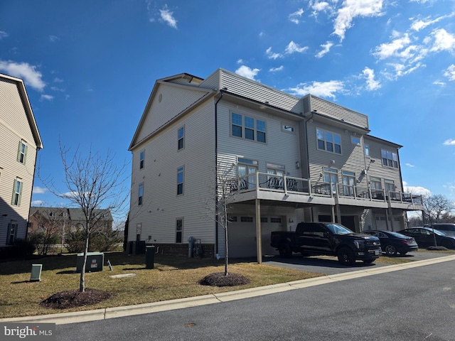 rear view of property featuring aphalt driveway, central AC unit, and an attached garage