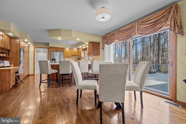 dining area featuring visible vents, baseboards, and hardwood / wood-style floors