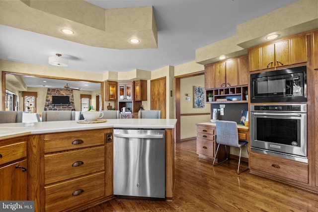 kitchen featuring dark wood-type flooring, light countertops, brown cabinetry, stainless steel appliances, and open shelves