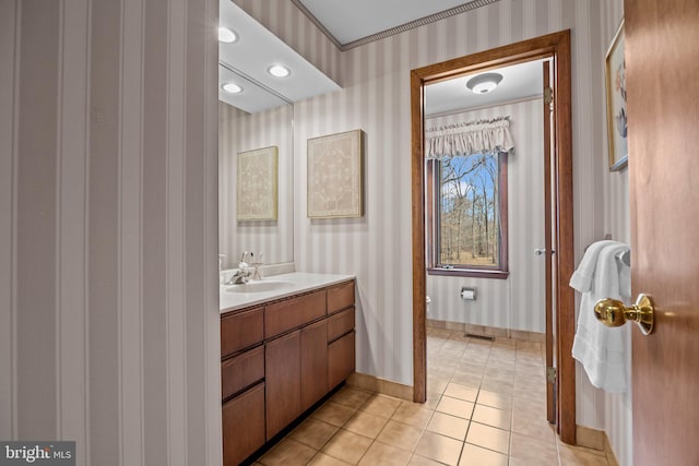 bathroom featuring wallpapered walls, baseboards, toilet, tile patterned floors, and vanity