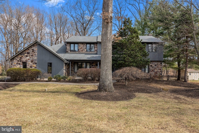 view of front of house with stone siding, a shingled roof, and a front yard