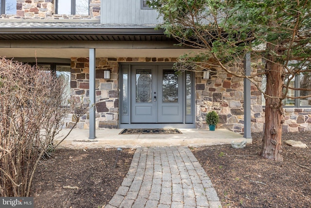 doorway to property featuring stone siding and french doors