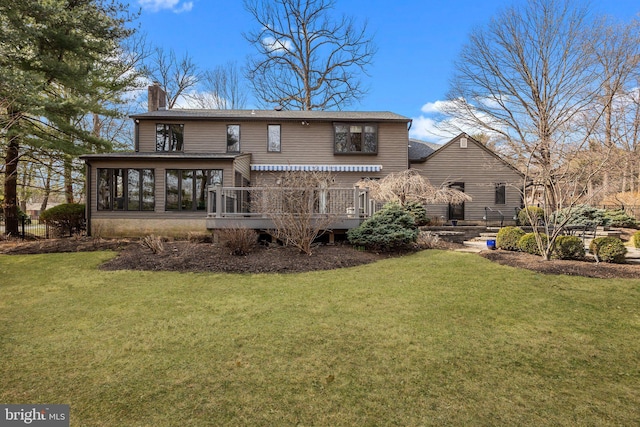 back of property featuring a lawn, a sunroom, and a chimney