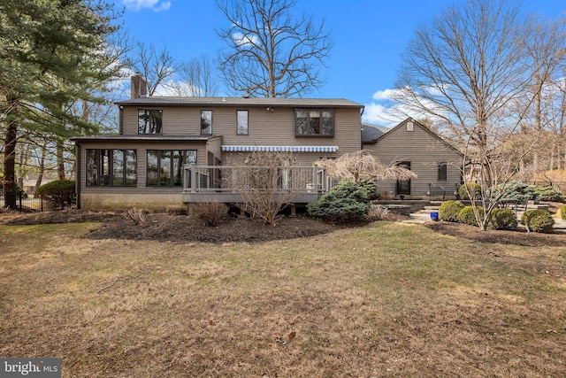 back of property featuring a yard, a chimney, and a sunroom