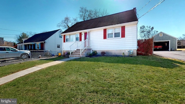 view of front of home featuring a detached garage, an outbuilding, a front lawn, and fence