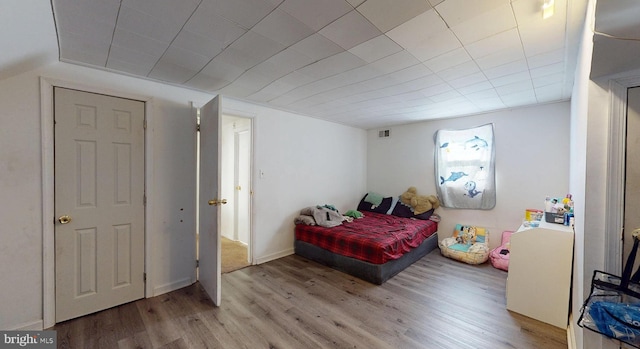 bedroom featuring visible vents and wood finished floors