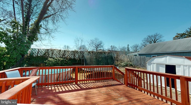 wooden deck with a storage shed and an outbuilding