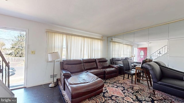 living area featuring stairway, baseboards, and wood finished floors