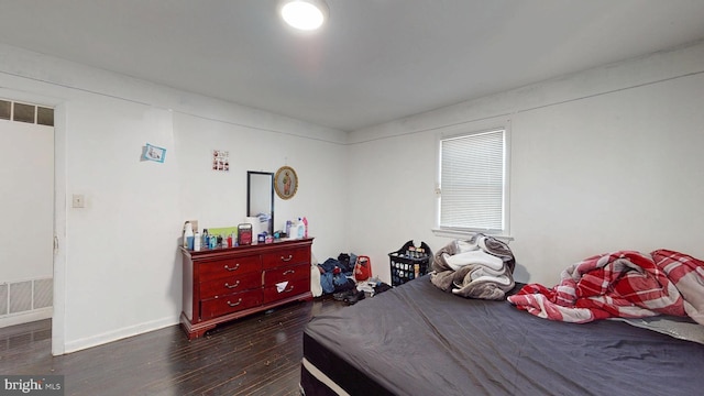 bedroom featuring wood finished floors, visible vents, and baseboards