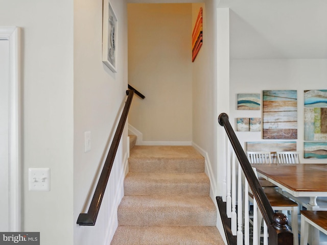 staircase with baseboards and carpet