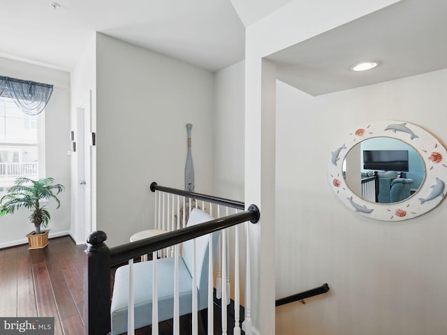 staircase with baseboards and wood finished floors