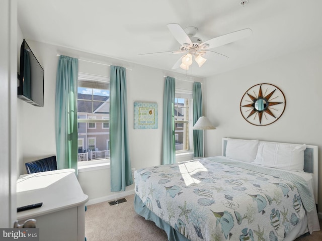 bedroom with multiple windows, visible vents, carpet floors, and ceiling fan