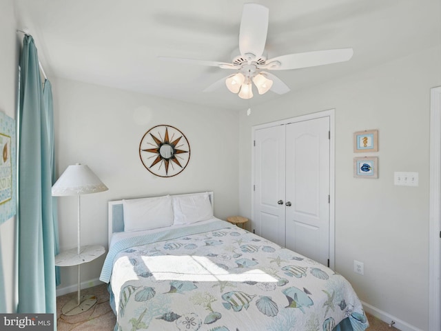 carpeted bedroom with a closet, baseboards, and ceiling fan