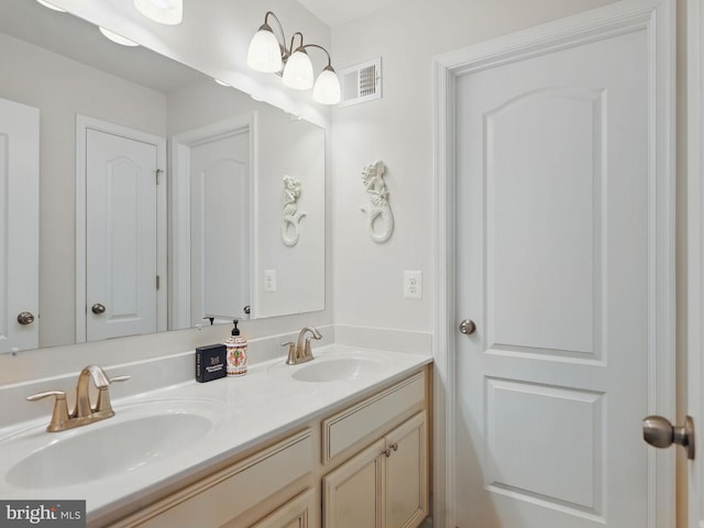 bathroom featuring double vanity, visible vents, and a sink