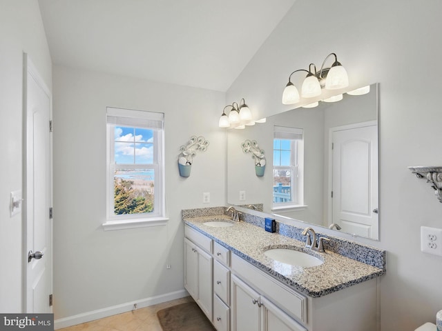 bathroom with lofted ceiling, a wealth of natural light, and a sink