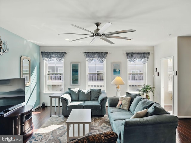 living area with baseboards, dark wood finished floors, and a ceiling fan