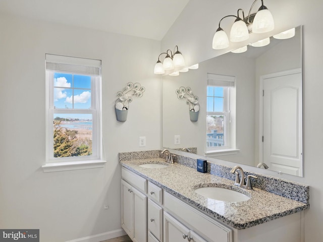 full bath featuring a sink, baseboards, and double vanity