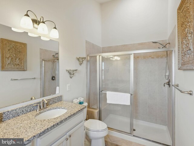 full bathroom with vanity, tile patterned floors, toilet, and a stall shower