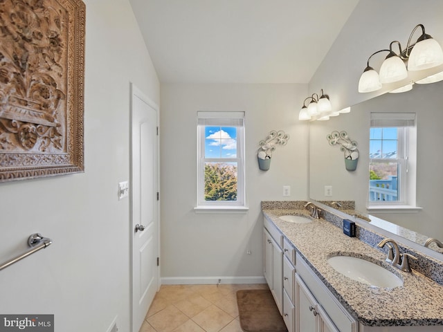 bathroom with tile patterned floors, double vanity, baseboards, and a sink