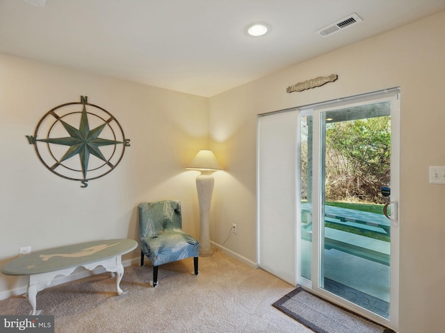 living area featuring visible vents, baseboards, and carpet