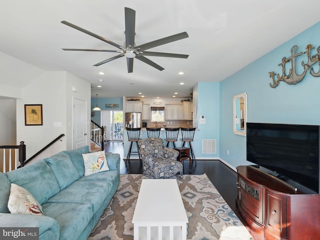 living area featuring visible vents, recessed lighting, stairs, and wood finished floors