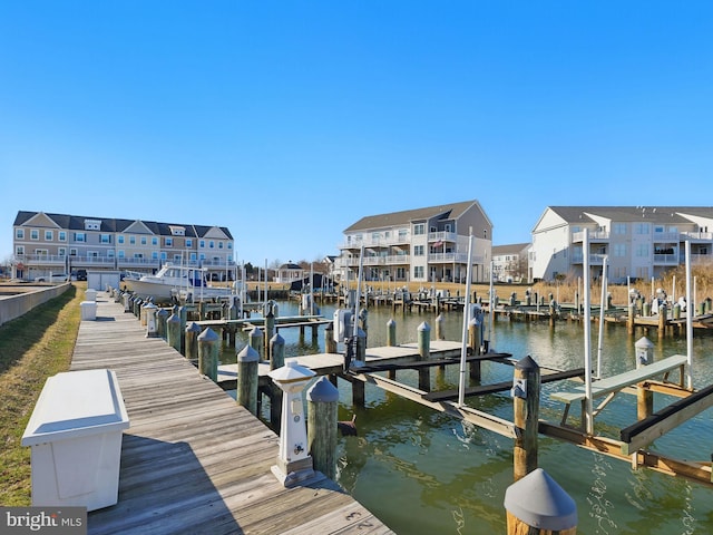 view of dock with boat lift, a residential view, and a water view