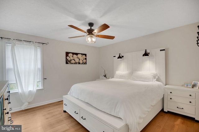 bedroom with light wood-type flooring, baseboards, and ceiling fan