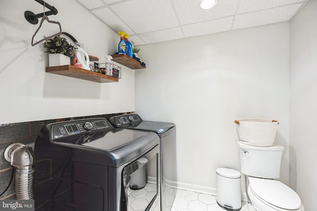 washroom featuring washing machine and clothes dryer, laundry area, and baseboards