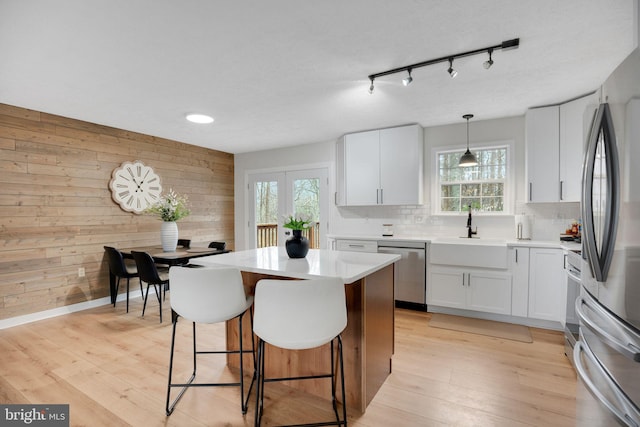 kitchen featuring a sink, a kitchen breakfast bar, light wood-style flooring, and stainless steel appliances