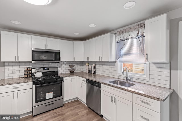 kitchen featuring white cabinets, appliances with stainless steel finishes, and a sink