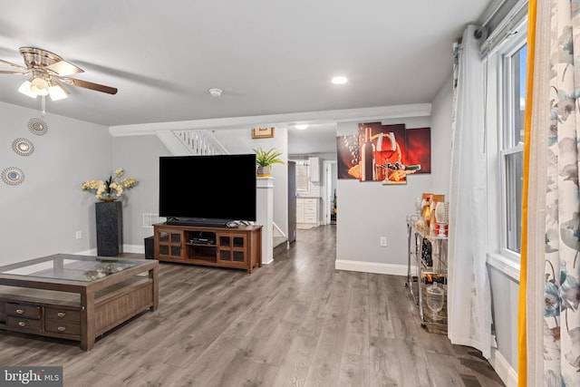 living area featuring baseboards, ceiling fan, stairs, recessed lighting, and wood finished floors