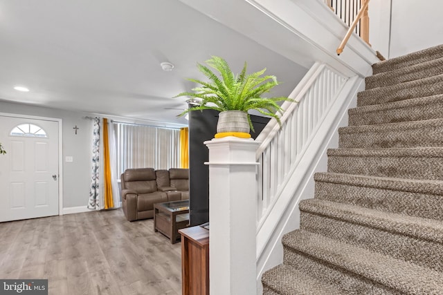 stairway featuring recessed lighting, baseboards, and wood finished floors