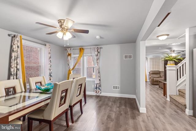 dining space featuring visible vents, wood finished floors, baseboards, and ceiling fan