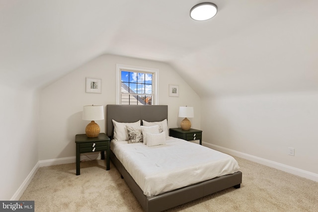 carpeted bedroom featuring lofted ceiling and baseboards