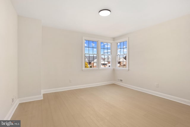 spare room with light wood-style flooring and baseboards