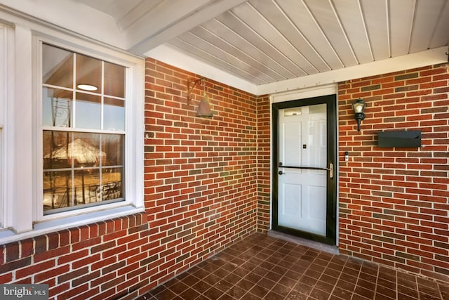 view of exterior entry with brick siding