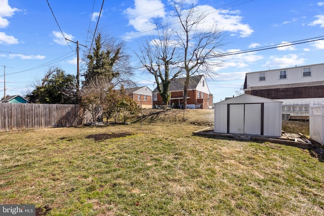 view of yard with an outdoor structure, a storage unit, and fence