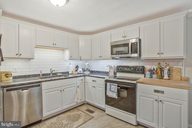 3719 3rd St, North Beach, MD 20714 - kitchen with stainless steel appliances, a sink, white cabinets, and backsplash
