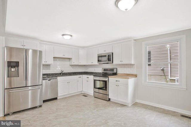 3719 3rd St, North Beach, MD 20714 - kitchen featuring appliances with stainless steel finishes, a sink, plenty of natural light, and baseboards
