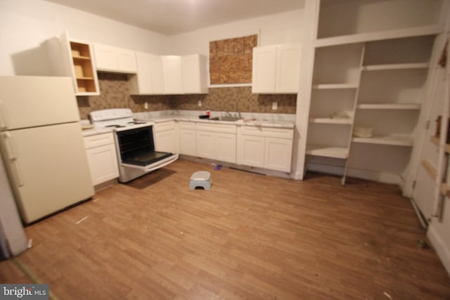 kitchen featuring range with electric cooktop, white cabinetry, freestanding refrigerator, and light wood-style floors