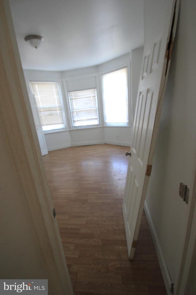 spare room with wood finished floors and baseboards