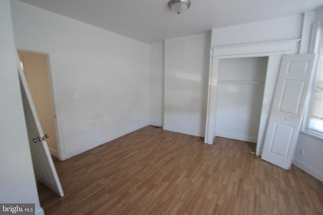 unfurnished bedroom with baseboards and wood finished floors