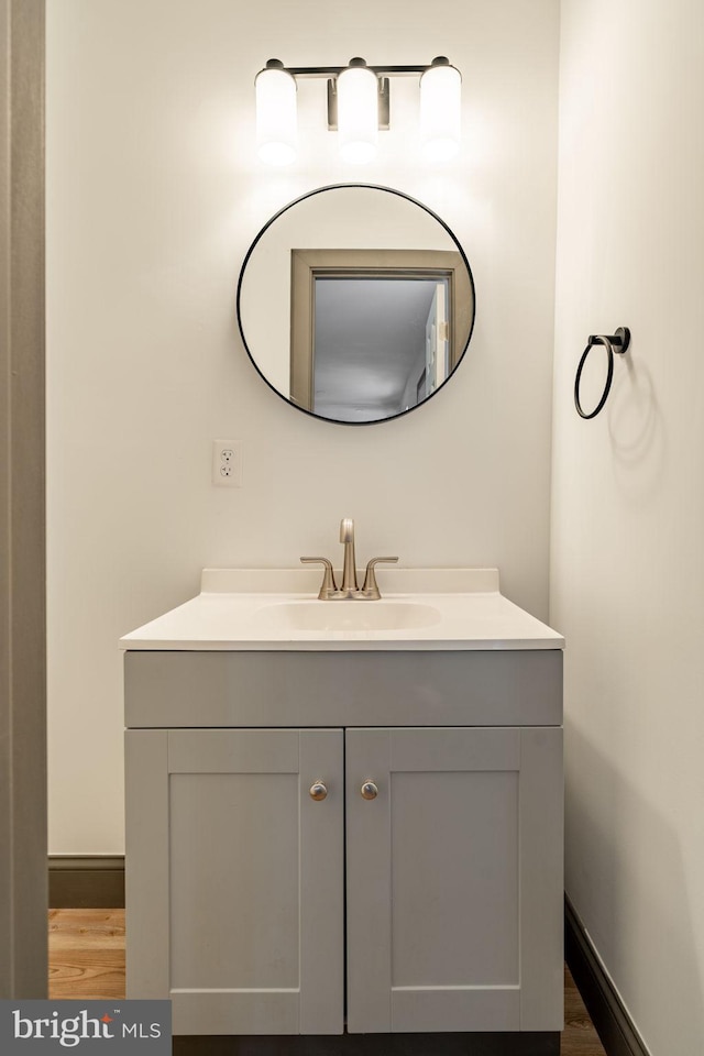 bathroom featuring baseboards, wood finished floors, and vanity