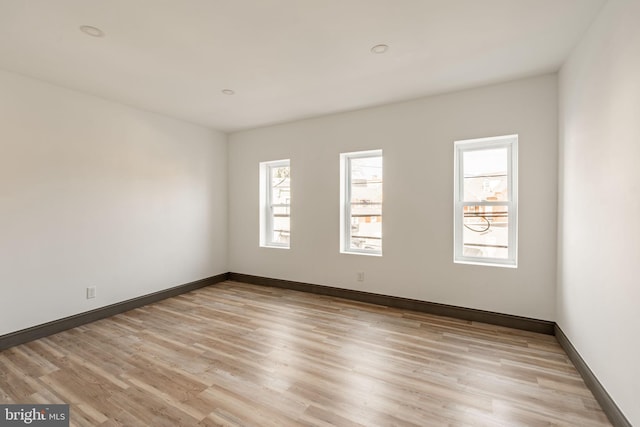 spare room featuring light wood-style flooring and baseboards