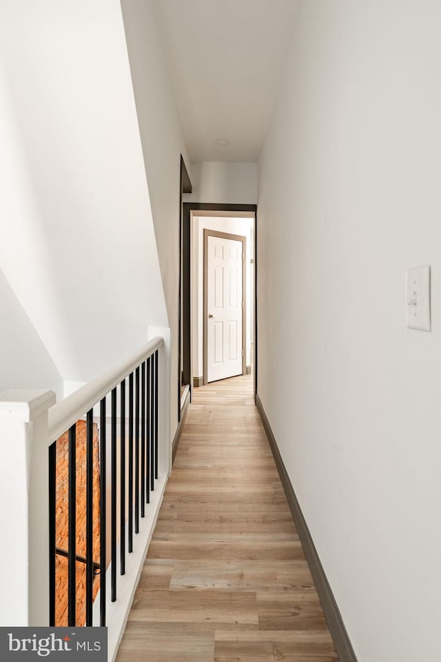 corridor featuring light wood-style floors and baseboards