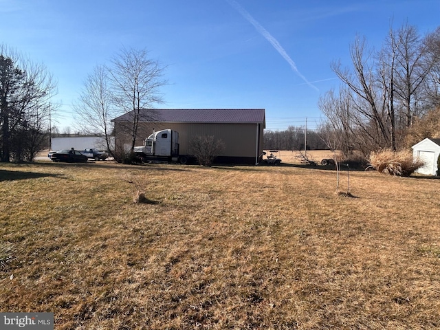 exterior space with an outbuilding, a lawn, and metal roof