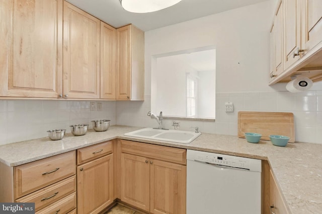 kitchen with decorative backsplash, white dishwasher, light brown cabinetry, and a sink