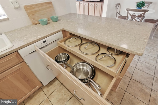 kitchen with decorative backsplash, light tile patterned floors, and light stone countertops